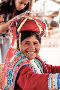 Mulher peruana em traje tradicional, a usar blusa bordada colorida típica do Peru